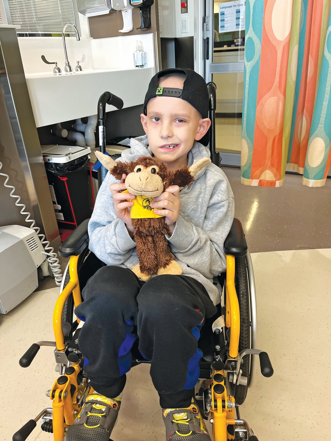 Brayden in wheelchair with Buddy the monkey at the beginning.
